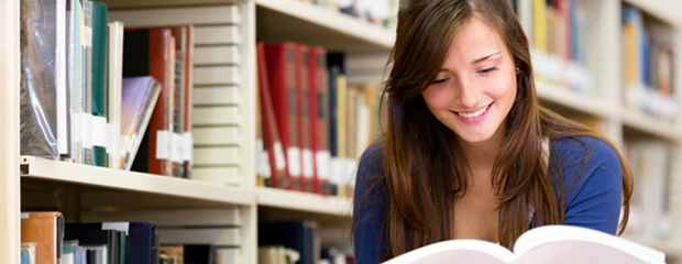 Frau liest ein Buch in einer Bibliothek