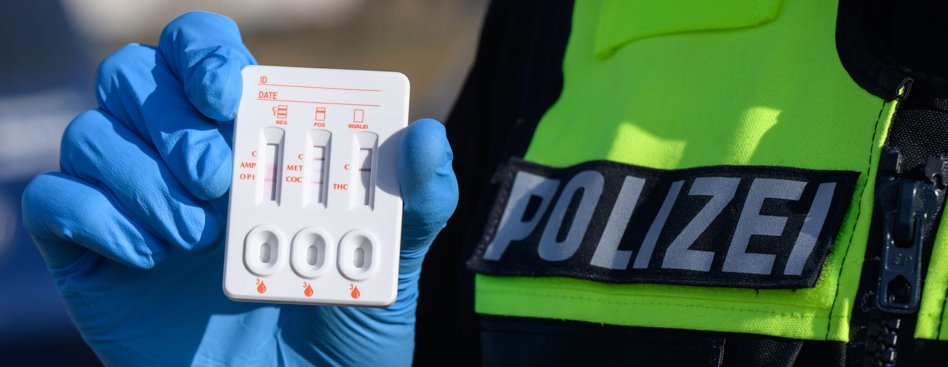 Ein Polizist zeigt einen positiven Drogen-Test auf THC (Cannabis).