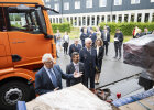 Herrmann und weitere Personen zwischen LKW-Transportern betrachten die Ladung