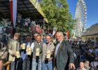 Gruppenfoto mit Innenminister Joachim Herrmann auf gut besuchtem Volksfest, im Hintergrund Riesenrad