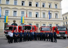 Gruppenbild vor Feuerwehrfahrzeugen