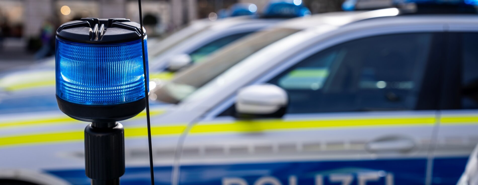 drei Polizisten in Einsatzuniform von hinten