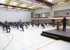 Blick auf die Anwesenden in der Turnhalle, die alle mit entsprechendem Mindestabstand platziert sind. Innenminister Joachim Herrmann spricht gerade auf der Bühne