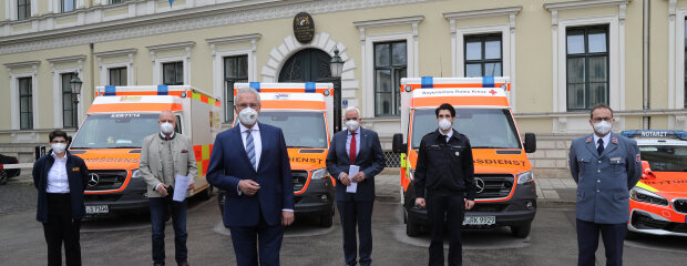 Innenminister Joachim Herrmann und weitere Personen vor Rettungswägen